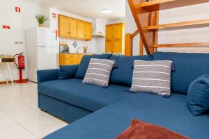 a blue couch with two pillows in a living room at Central Square in Povoação