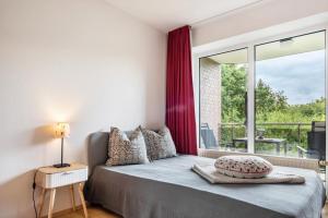 a bedroom with a bed and a large window at Sonne, Wind und Wetter in Wurster Nordseeküste
