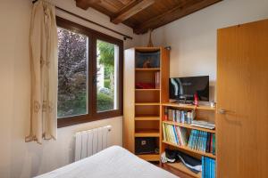 a bedroom with a bed and a book shelf with books at Casa Independiente En Angoustrine in Angoustrine