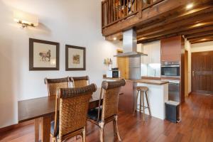 a kitchen with a wooden table and some chairs at Casa Independiente En Angoustrine in Angoustrine