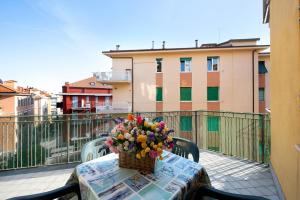 a basket of flowers sitting on a table on a balcony at Trilocale Mazzini con 2 balconi in Varazze