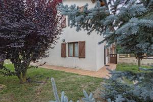 a white house with a window in a yard at Casa Independiente En Angoustrine in Angoustrine