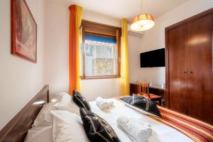 a bedroom with a bed with white sheets and pillows at By The Sea – Le Chele in Torre Lapillo