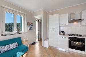 a living room with a blue couch and a kitchen at Casa Marincanto in Varazze