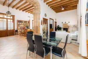 a living room with a glass table and black chairs at Ca la Senyora dels Arbres in Artá