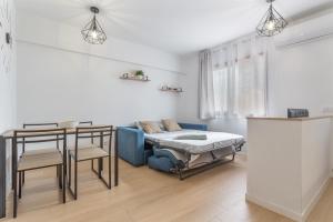 a room with a bed and a table and chairs at Playa De Las Américas - Oceanfront in Costa de Adeje