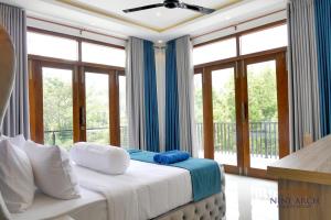 a bedroom with a bed and a balcony with windows at Ella, Nine Arch Holiday Resort in Ella