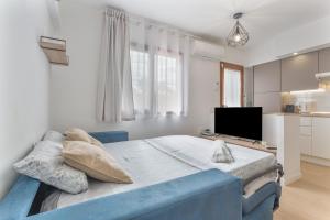 a bedroom with a blue bed and a television at Playa De Las Américas - Oceanfront in Costa de Adeje