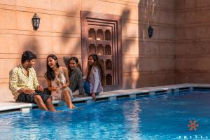 a group of people sitting next to a swimming pool at Zostel Jodhpur, Ratanada in Jodhpur