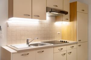 a kitchen with white cabinets and a sink at Hatzlhof Appartements in Vipiteno +71 photos