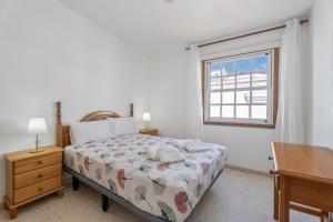 a bedroom with a bed and a desk and a window at Bonita Casa Annie in Abades