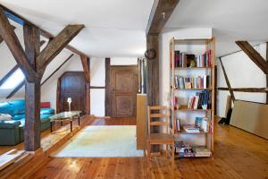 a living room with wooden beams and a book shelf at Altes Polchower Pfarrhaus in Alt Polchow