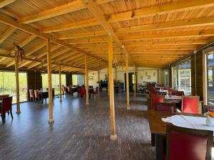 a dining room with wooden ceilings and tables and chairs at pınar kır evi in Artvin