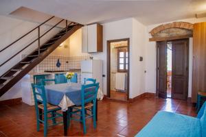 a kitchen and dining room with a table and a staircase at Vecchio Molino in Gavorrano