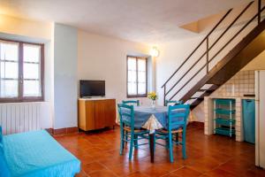 a living room with a table and blue chairs at Vecchio Molino in Gavorrano