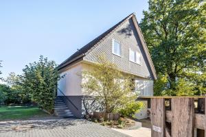 a house with a black roof and a fence at Gästehaus Oehm in Faßberg