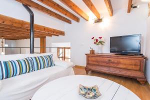 a living room with a couch and a tv on a wooden dresser at Sa Fusteria in Sóller