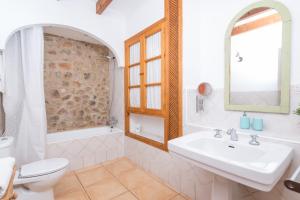 a white bathroom with a sink and a toilet at Sa Fusteria in Sóller +17 photos
