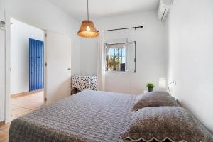 a bedroom with a bed in a white room at Beautiful Traditional House in Chipiona +21 photos