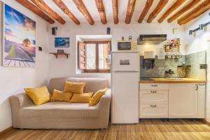 a living room with a couch and a kitchen at Apartamentos cuna del Genil in Güéjar-Sierra