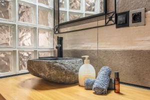 a bathroom with a stone sink on a wooden counter at Apartamentos cuna del Genil in Güéjar-Sierra +46 photos