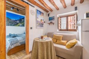 a living room with a couch and a bed at Apartamentos cuna del Genil in Güéjar-Sierra