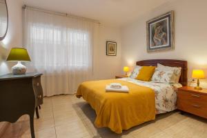 a bedroom with a bed with a yellow blanket at Amelie Apartment in Canet de Mar