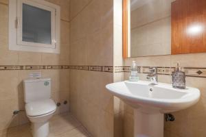 a bathroom with a sink and a toilet and a mirror at Amelie Apartment in Canet de Mar