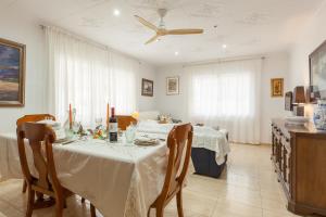 a dining room with two tables and a ceiling fan at Amelie Apartment in Canet de Mar