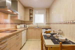 a kitchen with a table and some chairs in it at Amelie Apartment in Canet de Mar +9 photos