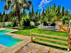 a wooden bench in a yard with a pool at Villavillanos in Otura