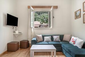 a living room with a blue couch and a window at El Padre Residence in Sívros