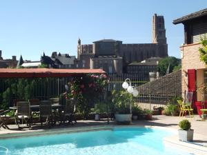 a backyard with a swimming pool and a table and chairs at La Chambre de Cécile in Albi