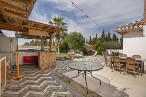 a patio with a table and chairs and a kitchen at Villavillanos in Otura