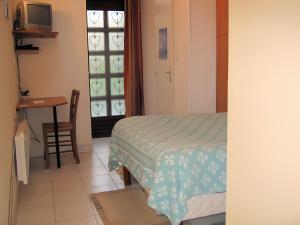 a bedroom with a bed and a table and a window at Studio chambre d'hôte in Panazol