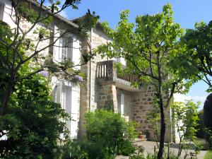 a stone house with a balcony on the side of it at Studio chambre d'hôte in Panazol