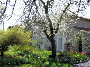 a house with a yard with flowers and a tree at Studio chambre d'hôte in Panazol