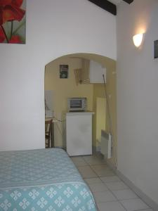 a small room with a bed and a kitchen at Studio chambre d'hôte in Panazol
