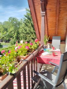 a table and chairs on a balcony with flowers at Chambres D'hôtes - Suite Pampas in Geiswiller +15 photos