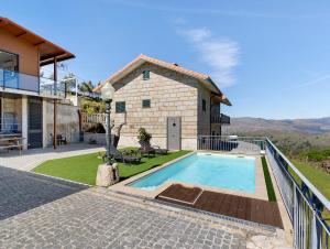 a house with a swimming pool next to a building at Casa Dona Florinda in Ermida