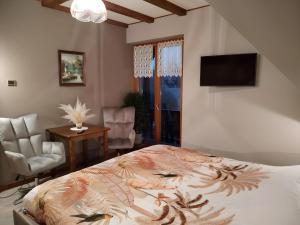 a bedroom with a bed and a flat screen tv at Chambres D'hôtes - Suite Pampas in Geiswiller