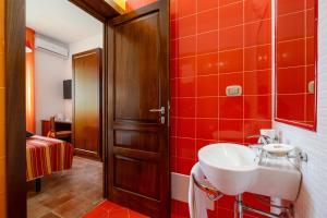 a bathroom with a sink and red tiles at By The Sea – Le Chele in Torre Lapillo +70 photos