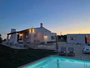 eine Villa mit Swimmingpool vor einem Haus in der Unterkunft Monte Barriga in Beja
