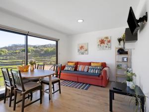 a living room with a red couch and a table at Casa Dona Florinda in Ermida