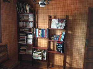 a book shelf filled with books in a corner at Chaleureuse Maison de Montagne in Garin