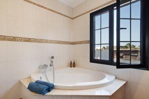 a large white tub in a bathroom with a window at Casa Jess in Tías +12 photos