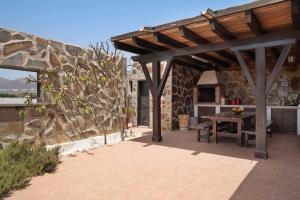 a wooden pergola on a patio with a table at Casa Jess in Tías
