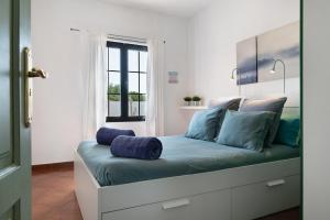 a bed with blue pillows on it in a room at Casa Jess in Tías