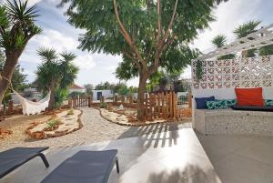 a patio with a couch and a hammock and trees at Moncoração Village in Moncarapacho