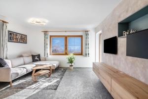 a living room with a couch and a tv at Pixnerhof - Ferienwohnung Golden in Kastelbell-Tschars